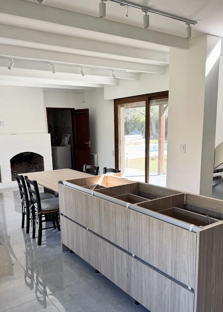 Cocina blanca iluminada por un gran ventanal al jardín